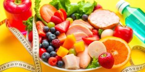 Colorful healthy food with measuring tape and water bottle.