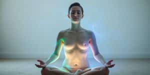 Person meditating, calm, amidst swirling colors.