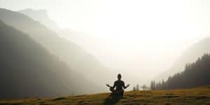 Person meditating peacefully outdoors.